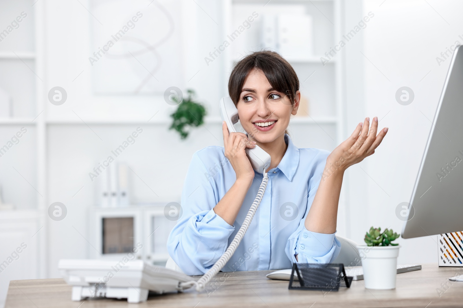 Photo of Portrait of receptionist at wooden desk in office