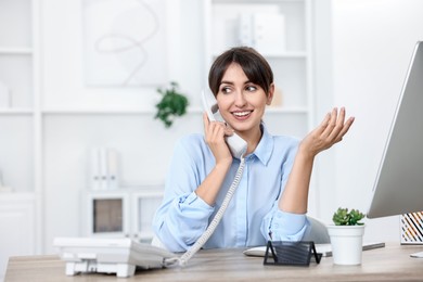 Portrait of receptionist at wooden desk in office