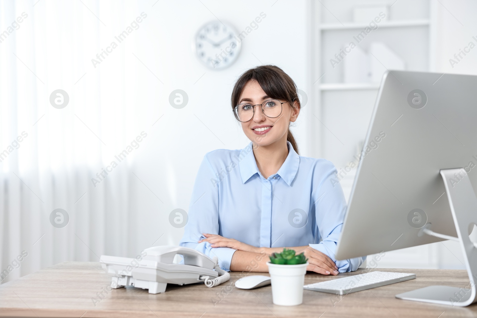 Photo of Portrait of receptionist at wooden desk in office