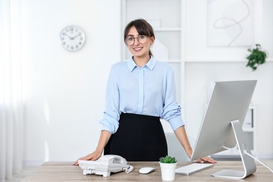 Photo of Portrait of receptionist at wooden desk in office