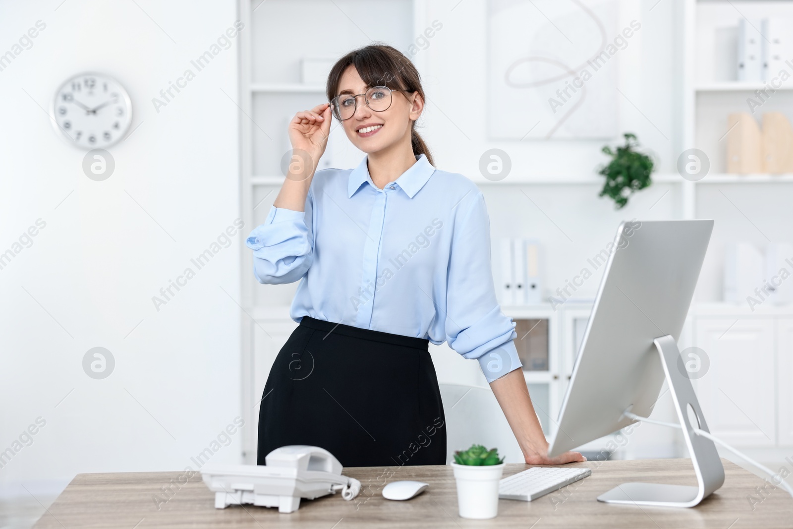 Photo of Portrait of receptionist at wooden desk in office