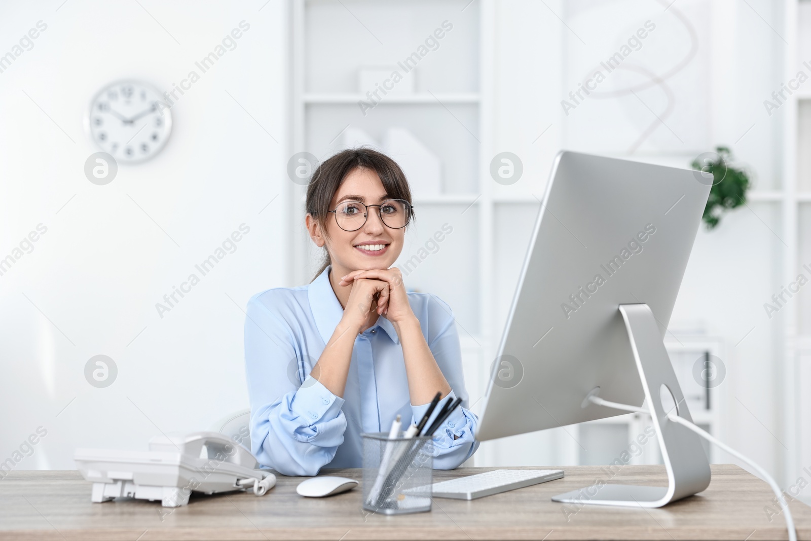 Photo of Portrait of receptionist at wooden desk in office