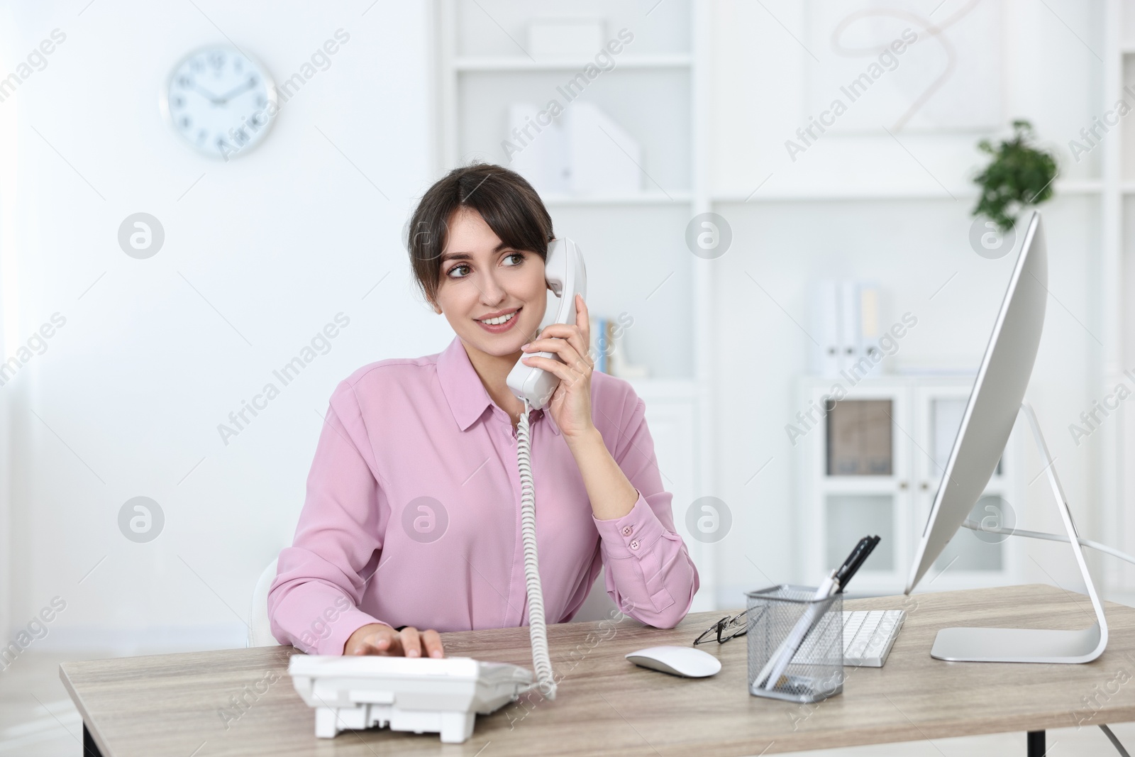 Photo of Portrait of receptionist at wooden desk in office