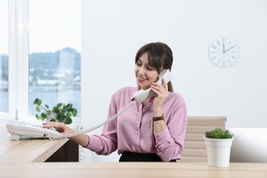 Photo of Portrait of receptionist at wooden desk in office