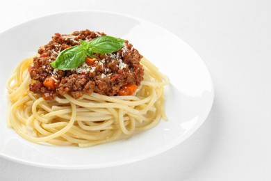 Photo of Plate with tasty pasta bolognese on white table, closeup