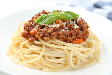 Photo of Tasty pasta bolognese with basil on white plate, closeup