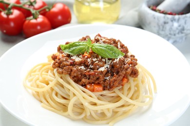 Photo of Delicious pasta bolognese with basil on table, closeup