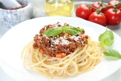 Photo of Delicious pasta bolognese with basil on table, closeup