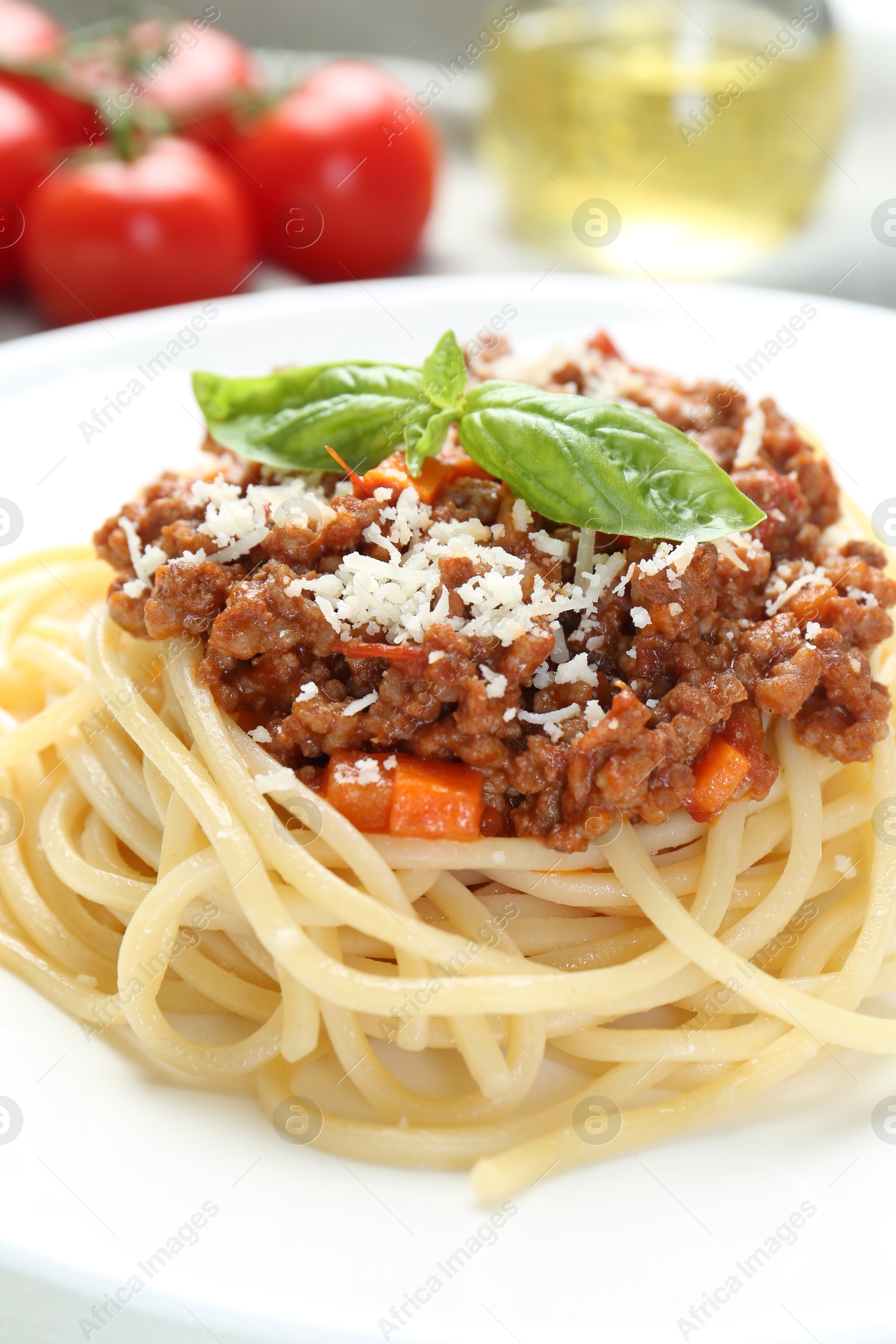 Photo of Delicious pasta bolognese with basil on table, closeup