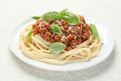 Photo of Tasty pasta bolognese with basil on white table, closeup