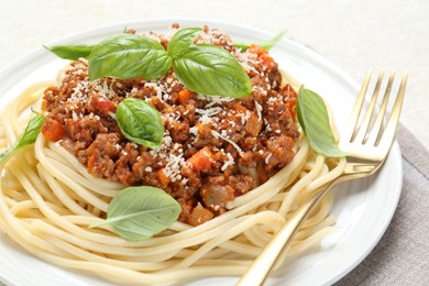 Photo of Delicious pasta bolognese with basil on light table, closeup