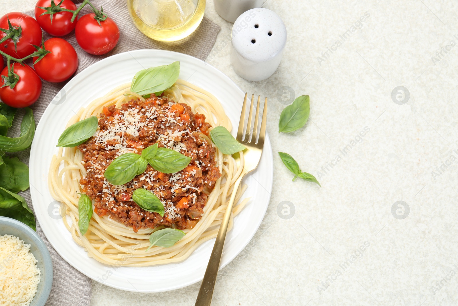 Photo of Delicious pasta bolognese served on light table, flat lay. Space for text