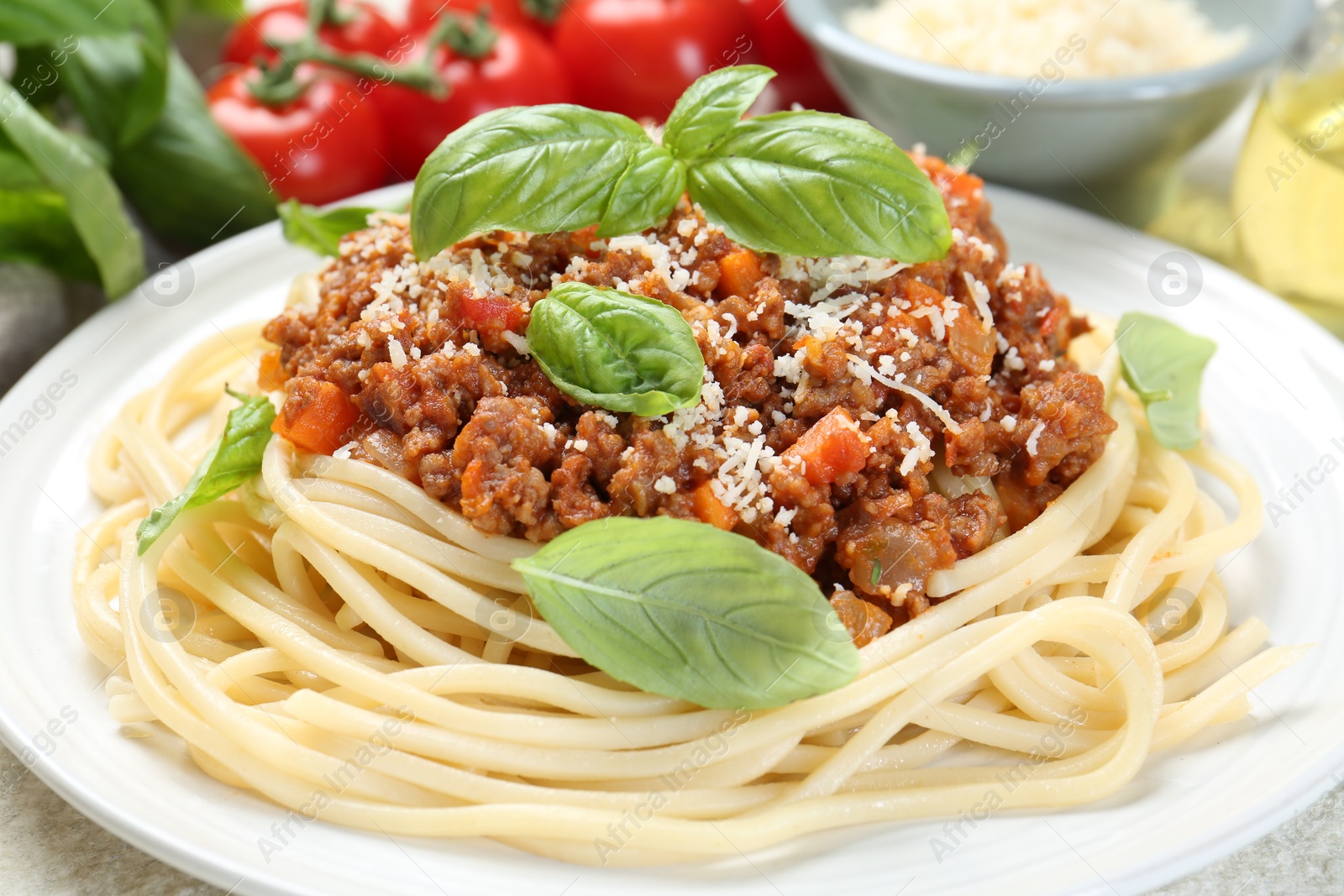 Photo of Delicious pasta bolognese with basil on table, closeup