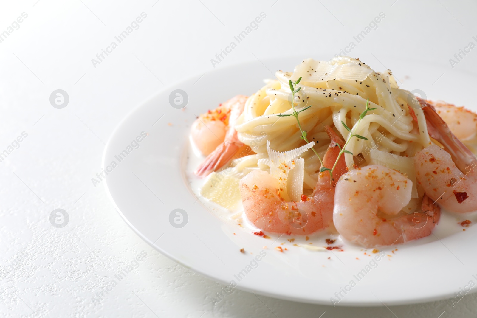 Photo of Delicious pasta with shrimps and cheese on white table, closeup