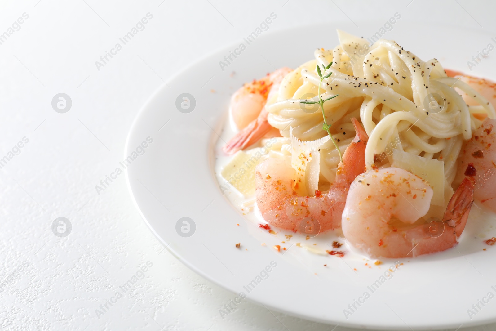 Photo of Delicious pasta with shrimps and cheese on white table, closeup