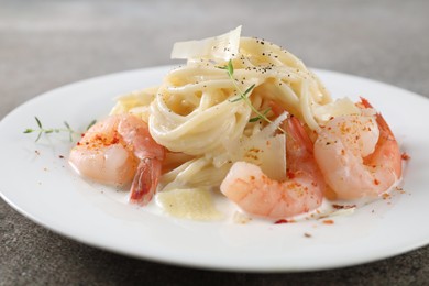 Photo of Delicious pasta with shrimps and cheese on grey table, closeup