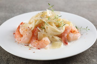 Photo of Delicious pasta with shrimps and cheese on grey table, closeup