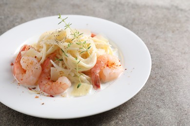 Photo of Delicious pasta with shrimps and cheese on grey table, closeup