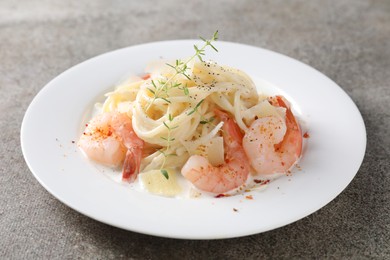 Photo of Delicious pasta with shrimps and cheese on grey table, closeup