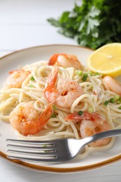 Photo of Delicious pasta with shrimps, green onion and fork on white table, closeup