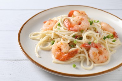 Photo of Delicious pasta with shrimps and green onion on white wooden table, closeup