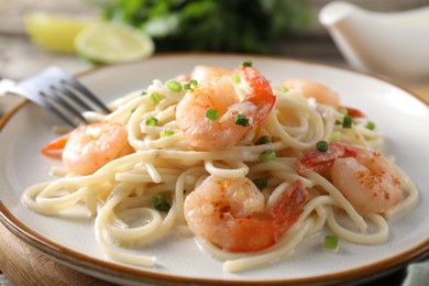 Photo of Delicious pasta with shrimps and green onions on table, closeup