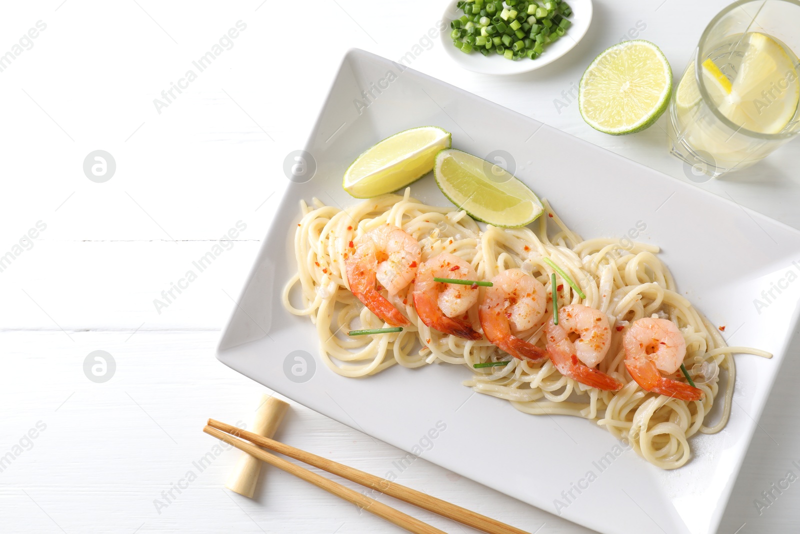 Photo of Delicious pasta with shrimps served on white wooden table, top view