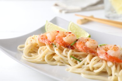 Photo of Delicious pasta with shrimps and green onions on white table, closeup