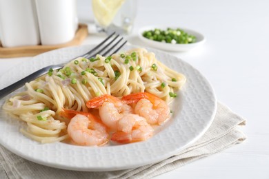 Photo of Delicious pasta with shrimps and green onions on white table, closeup