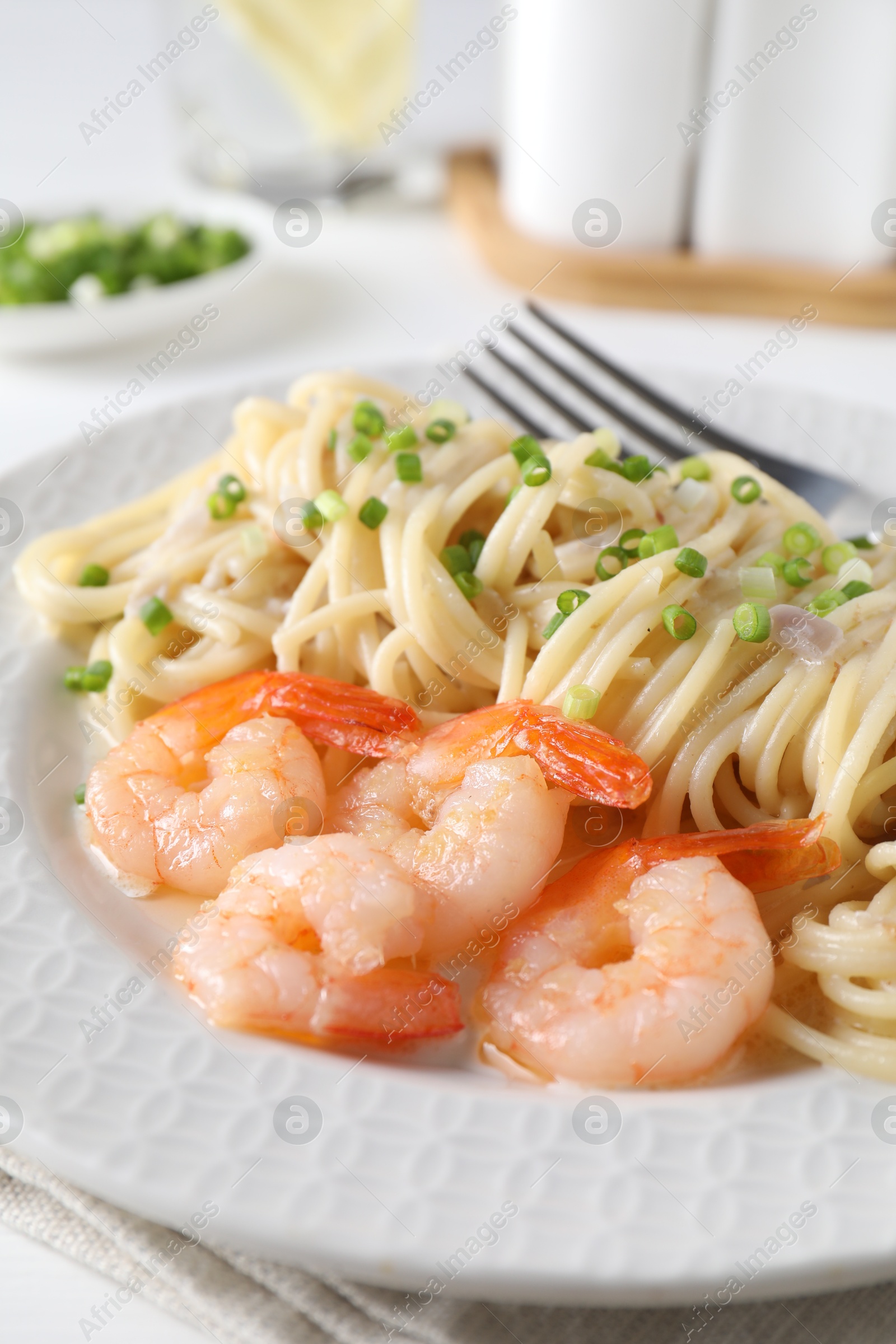 Photo of Delicious pasta with shrimps and green onions on table, closeup