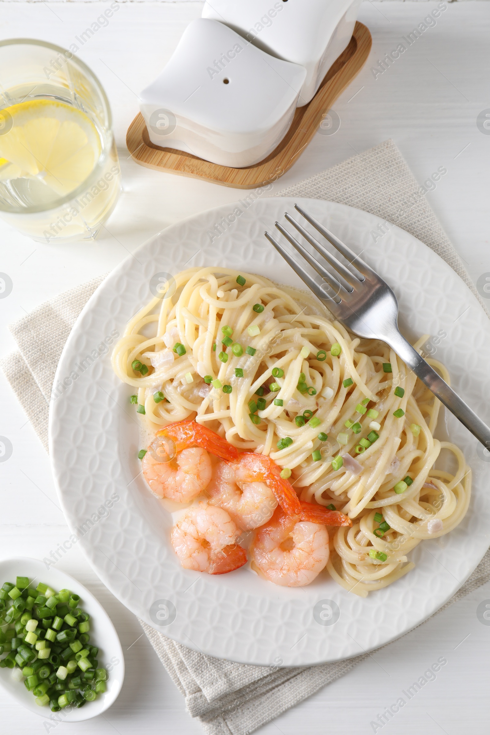 Photo of Delicious pasta with shrimps served on white wooden table, top view