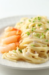 Photo of Delicious pasta with shrimps and green onions on table, closeup