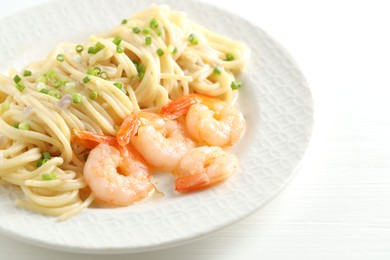 Photo of Delicious pasta with shrimps and green onions on white wooden table, closeup