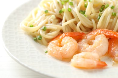 Photo of Delicious pasta with shrimps and green onions on white table, closeup