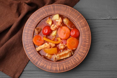 Tasty homemade stew with vegetables on grey wooden table, top view