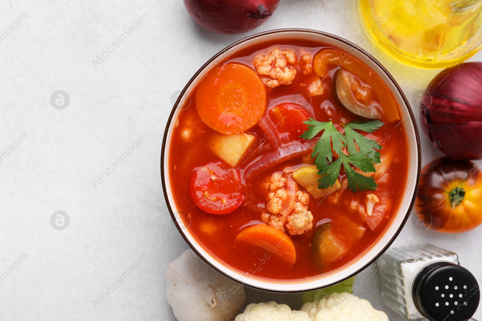 Photo of Tasty homemade stew with vegetables on white table, flat lay. Space for text