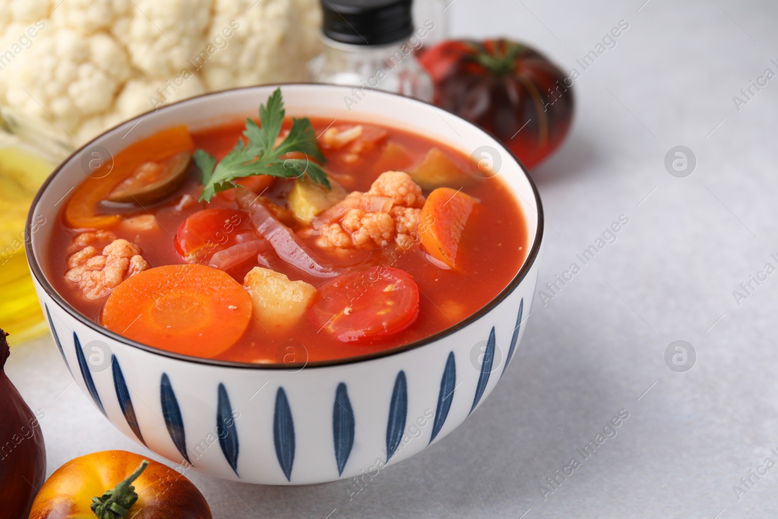 Photo of Tasty homemade stew with vegetables on white table, closeup. Space for text