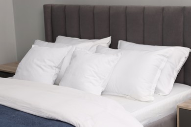 Photo of Many soft pillows on bed at home