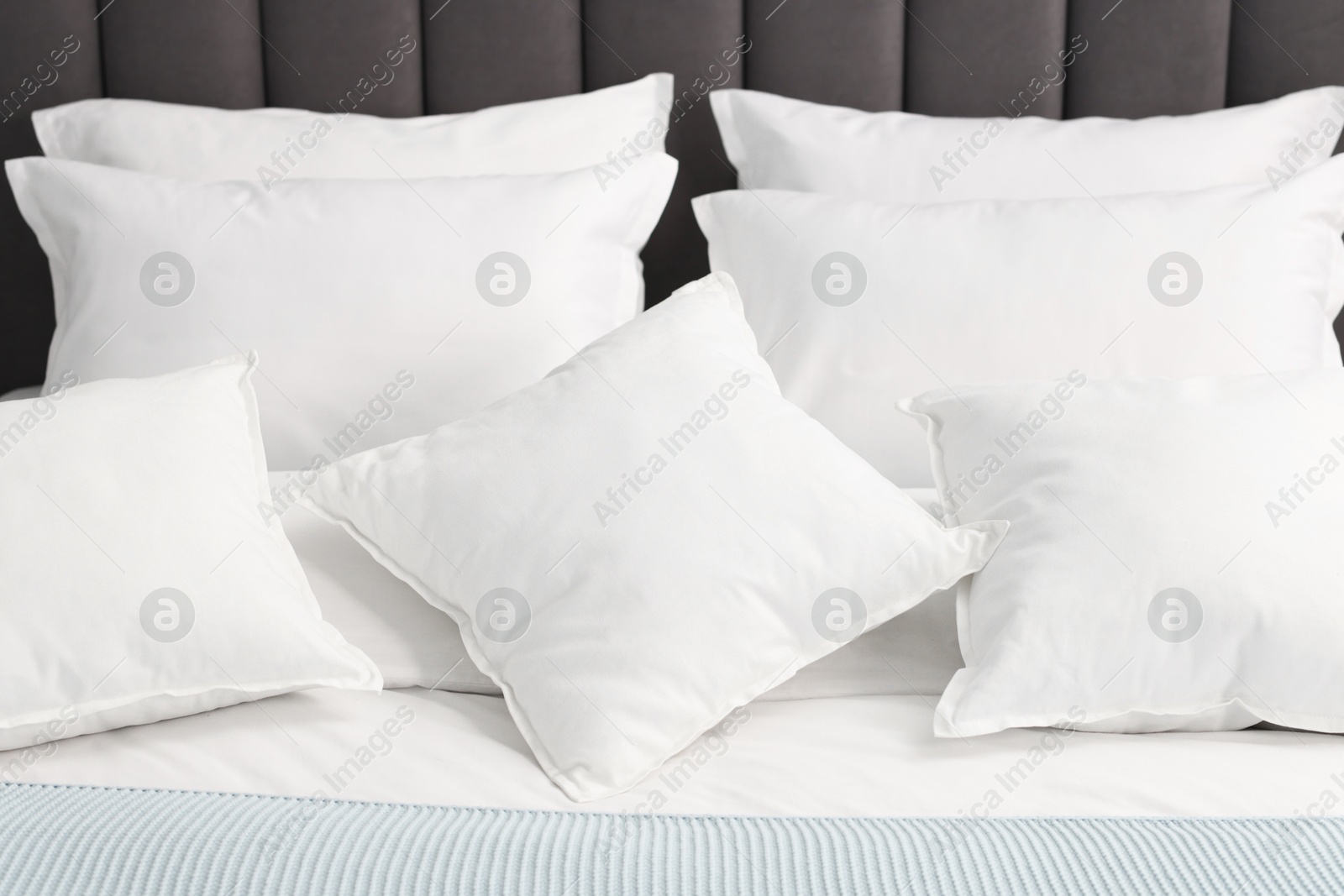 Photo of Many soft pillows on bed at home, closeup