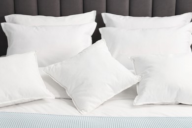 Many soft pillows on bed at home, closeup