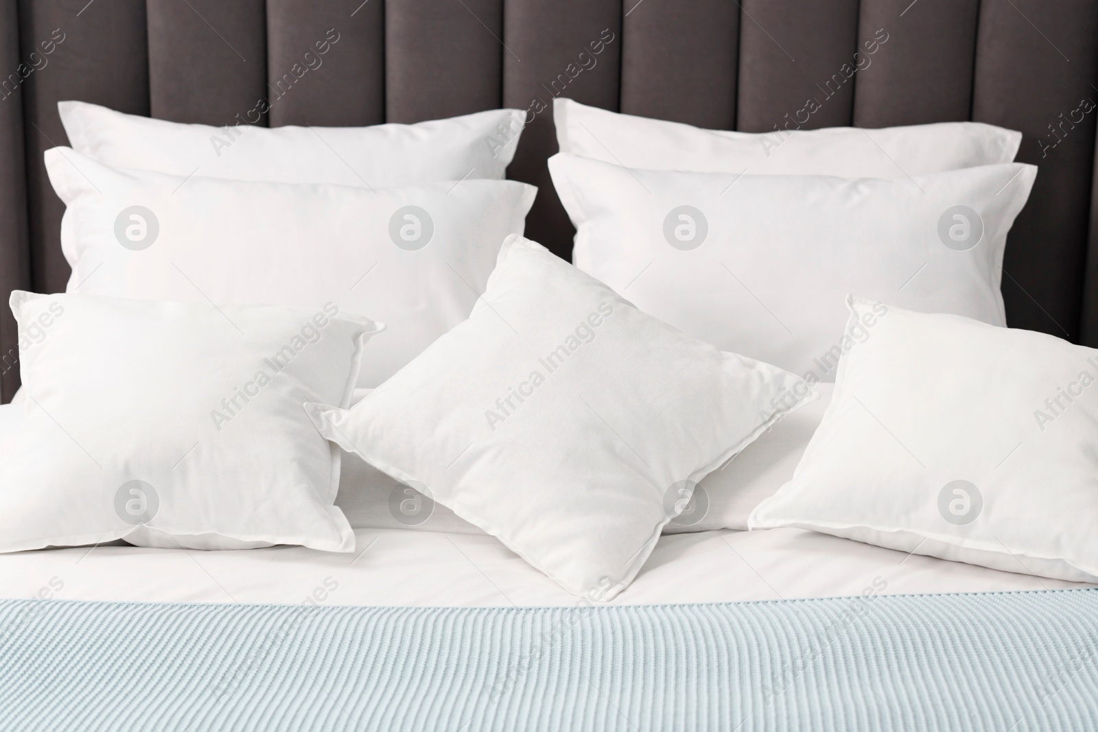 Photo of Many soft pillows on bed at home, closeup