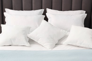 Photo of Many soft pillows on bed at home, closeup