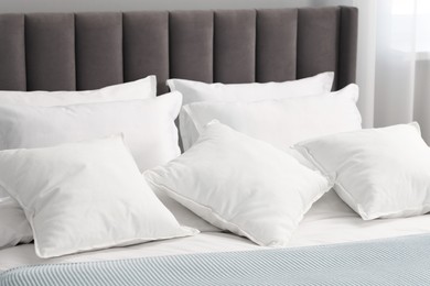 Many soft pillows on bed at home