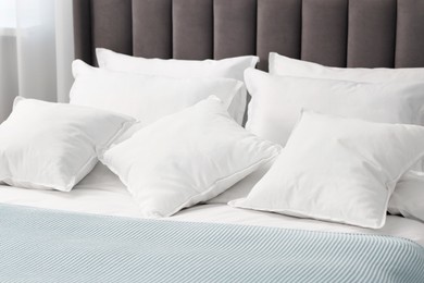 Many soft pillows on bed at home