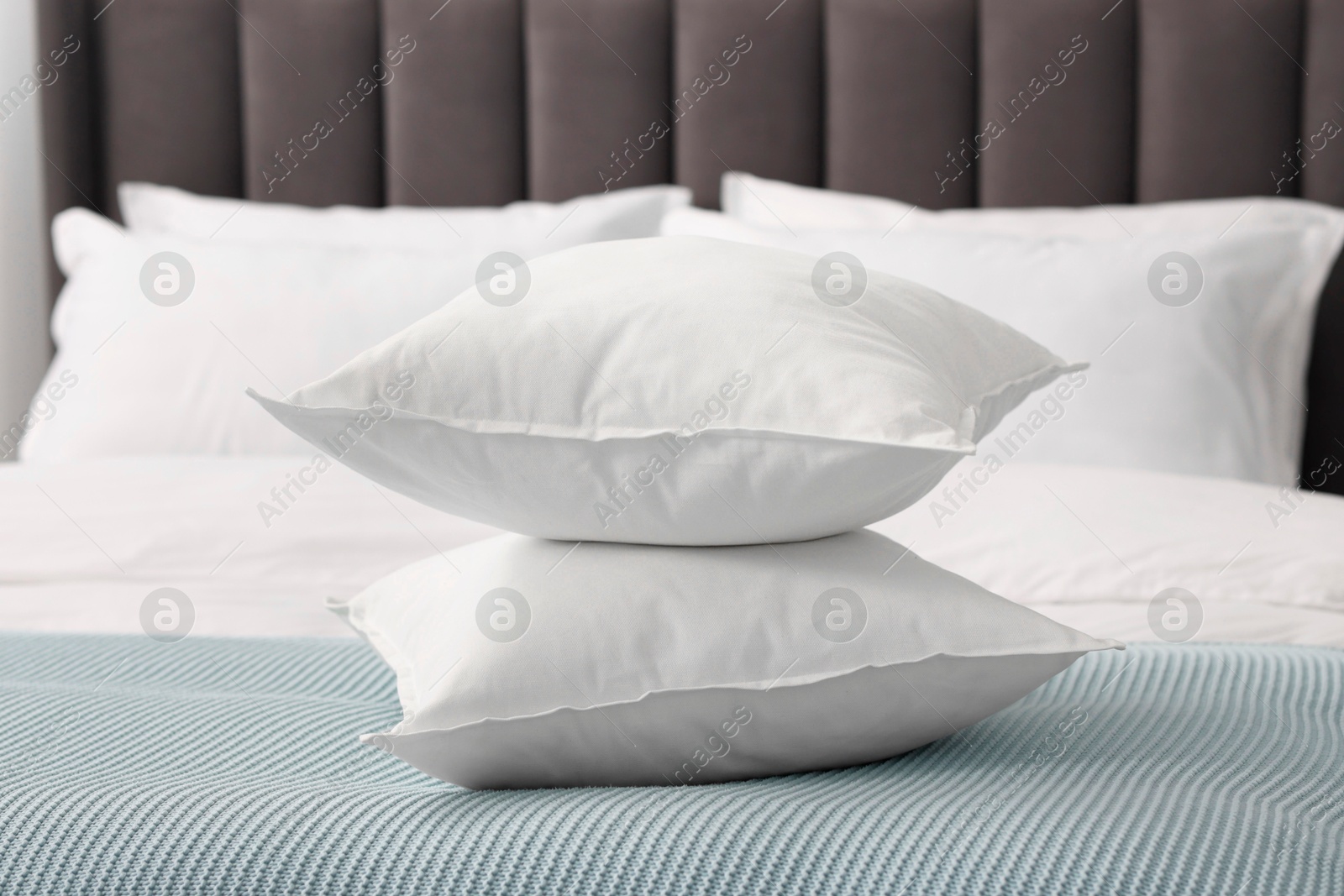 Photo of Many soft pillows on bed at home