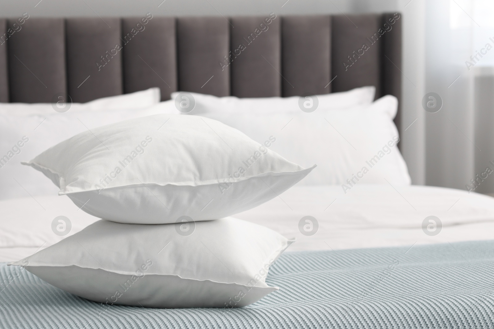 Photo of Many soft pillows on bed at home