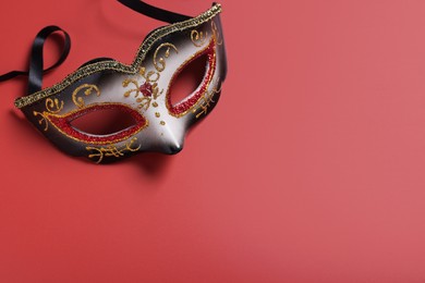 Beautiful carnival mask on red background, top view. Space for text