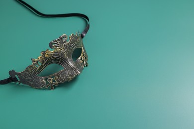 Photo of One beautiful carnival mask on teal background, space for text