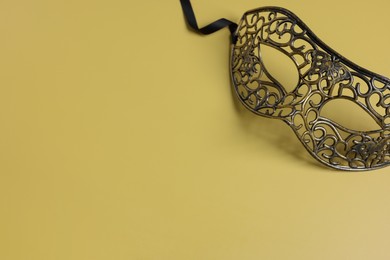 Photo of Beautiful carnival mask on yellow background, space for text