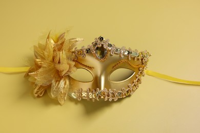 Photo of One beautiful carnival mask on yellow background